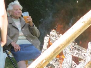 A woman sitting in a chair next to a fire.