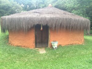 An adobe hut with a thatched roof.