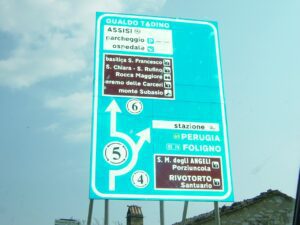 A blue and white sign with arrows pointing in different directions.