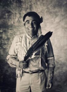 A black and white photo of a man holding a feather.