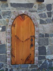 A wooden door on a stone wall.
